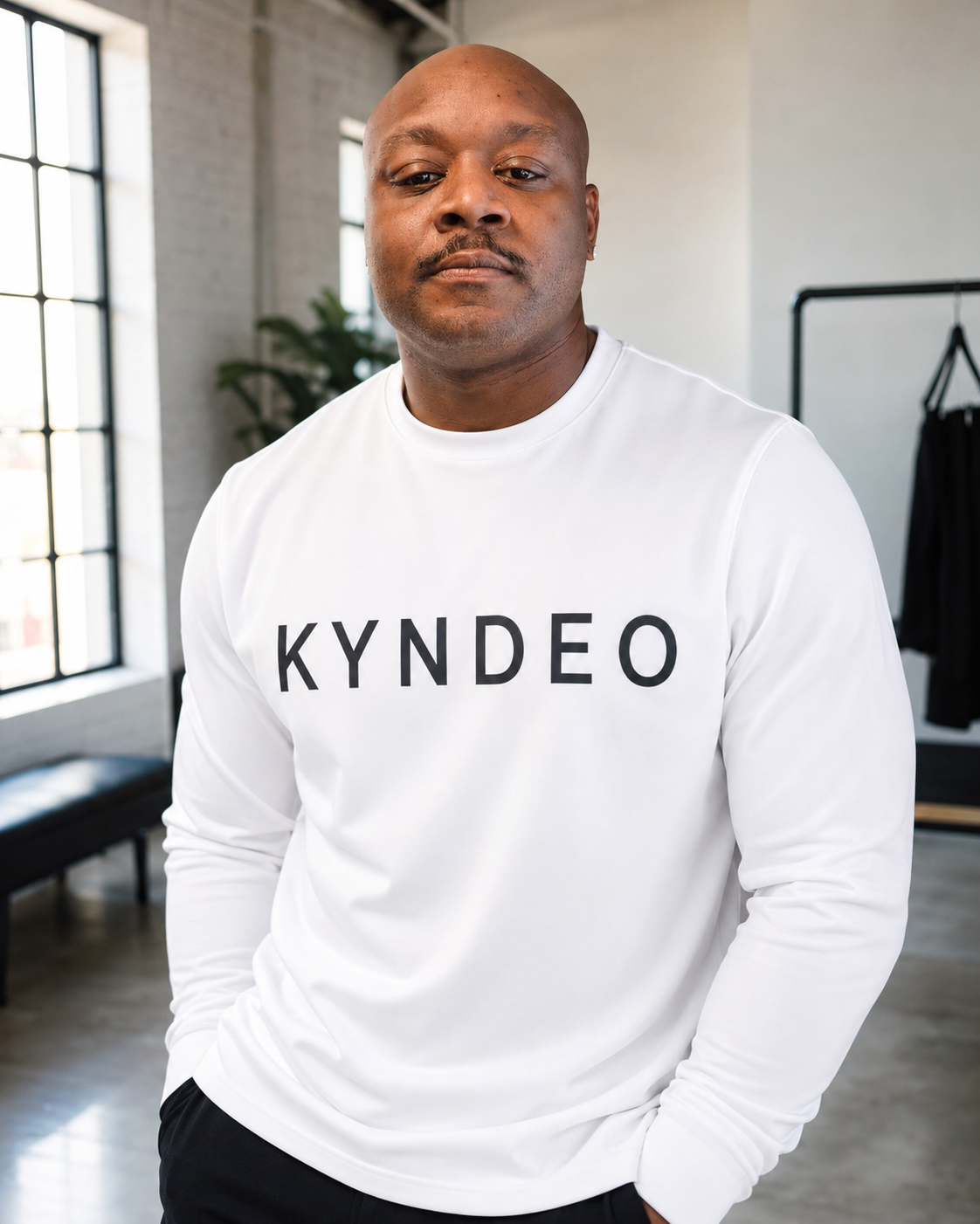 Bryan Frazier, founder and designer of KYNDEO Activewear, wearing a white KYNDEO shirt