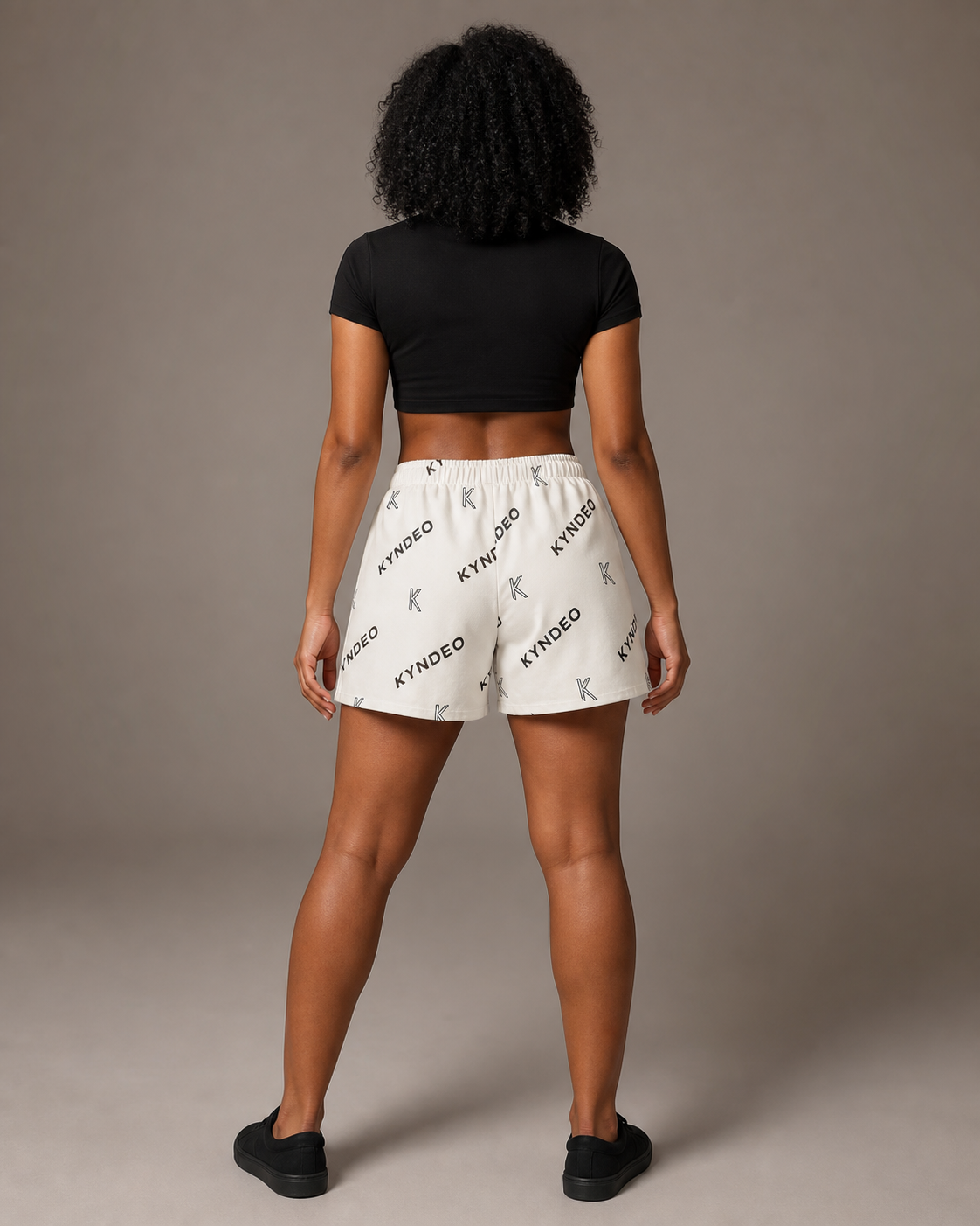 Black female model wearing KYNDEO Ember Court Short, full back view