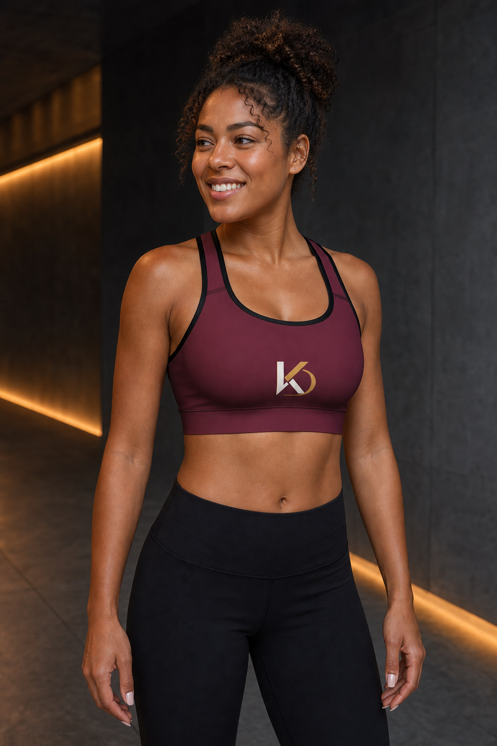 Afro-Latina woman wearing KYNDEO Oxblood Sports Bra, left front view