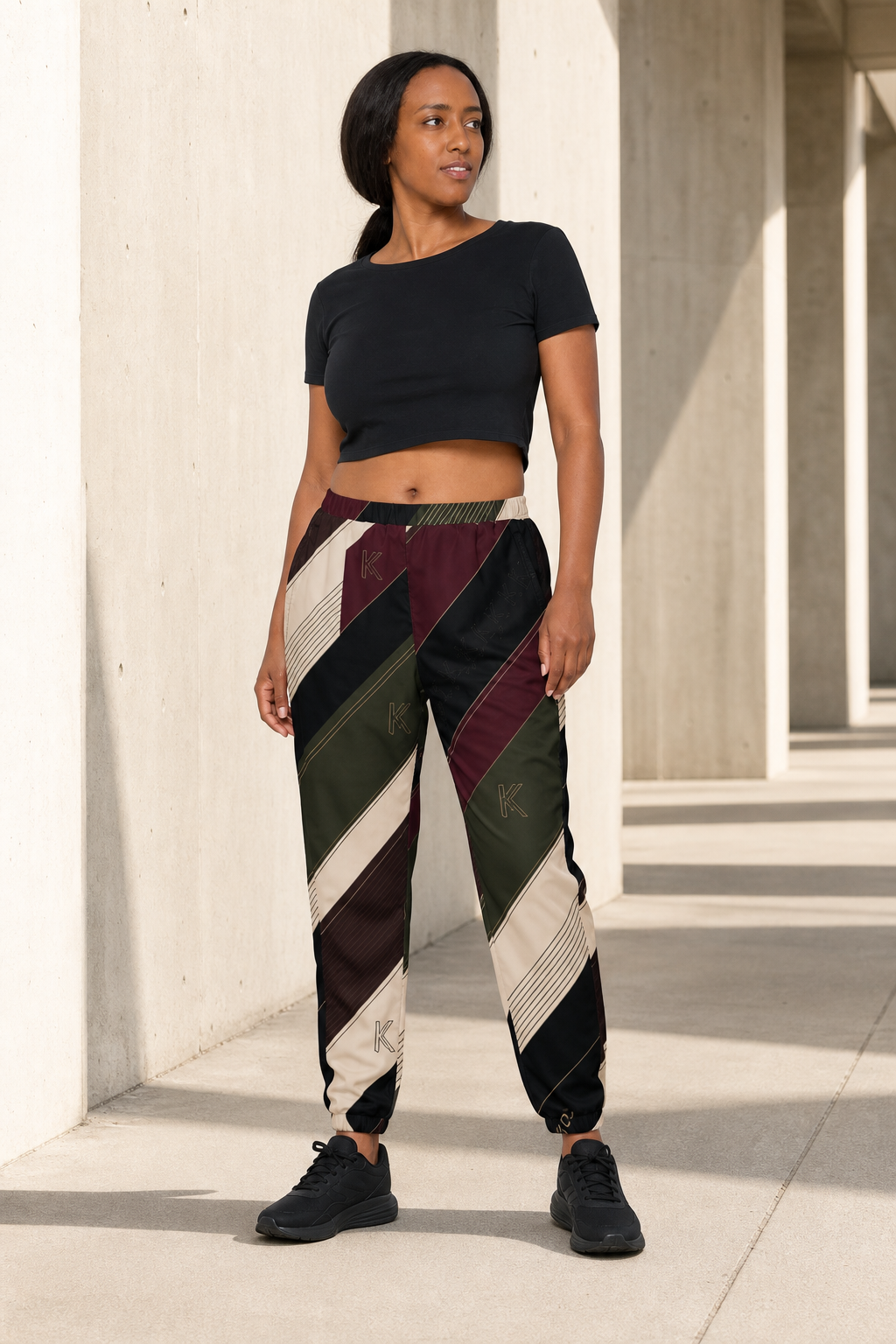 KYNDEO Velocity Track Pant on Afro-Latina model, front three-quarter view
