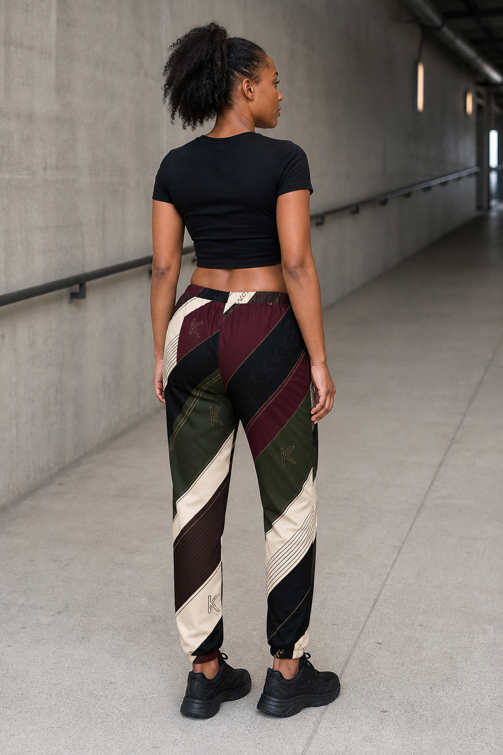 KYNDEO Velocity Track Pant on Black female model, rear three-quarter view