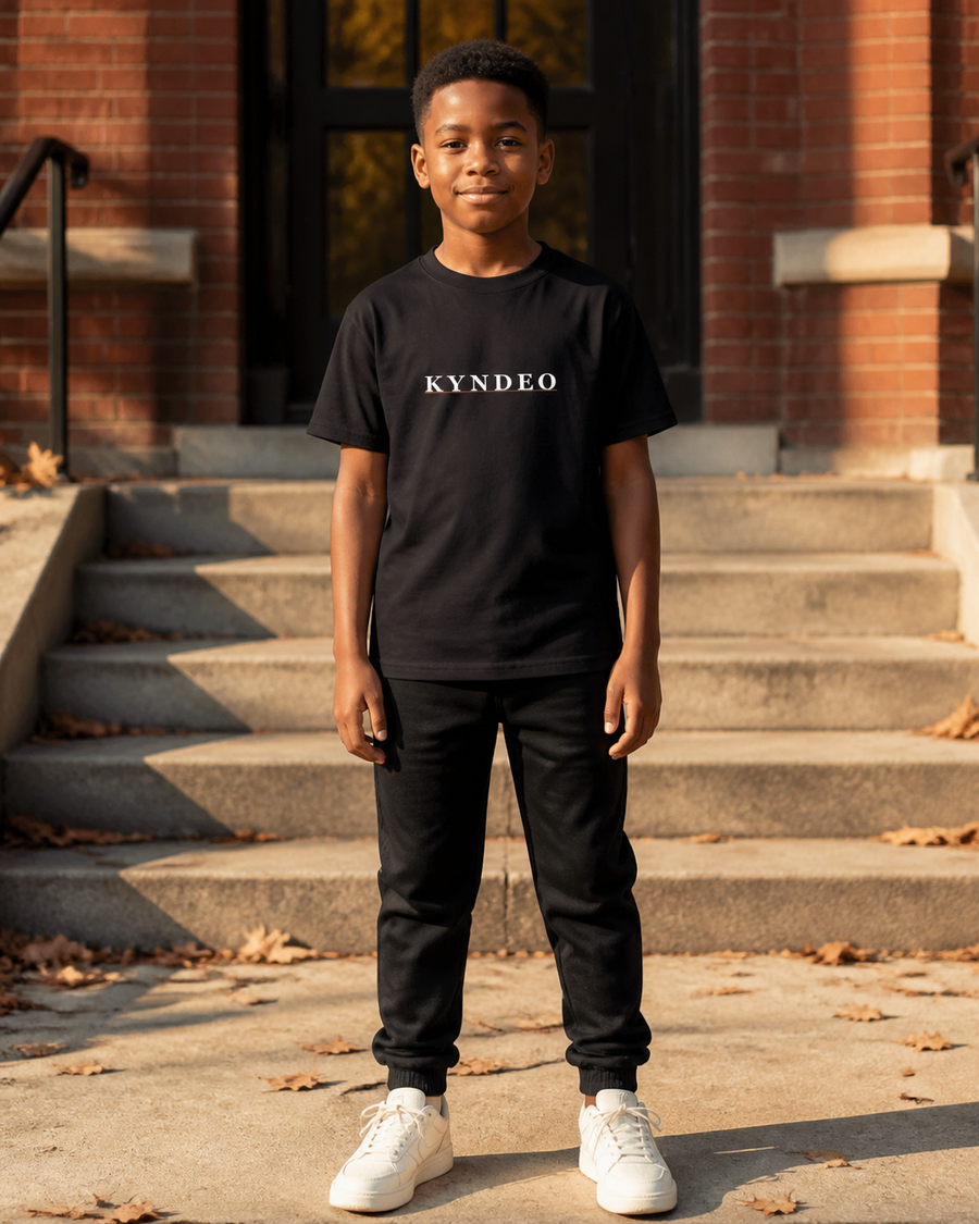 Black KYNDEO Youth Core Tee front on a Black boy model in fall