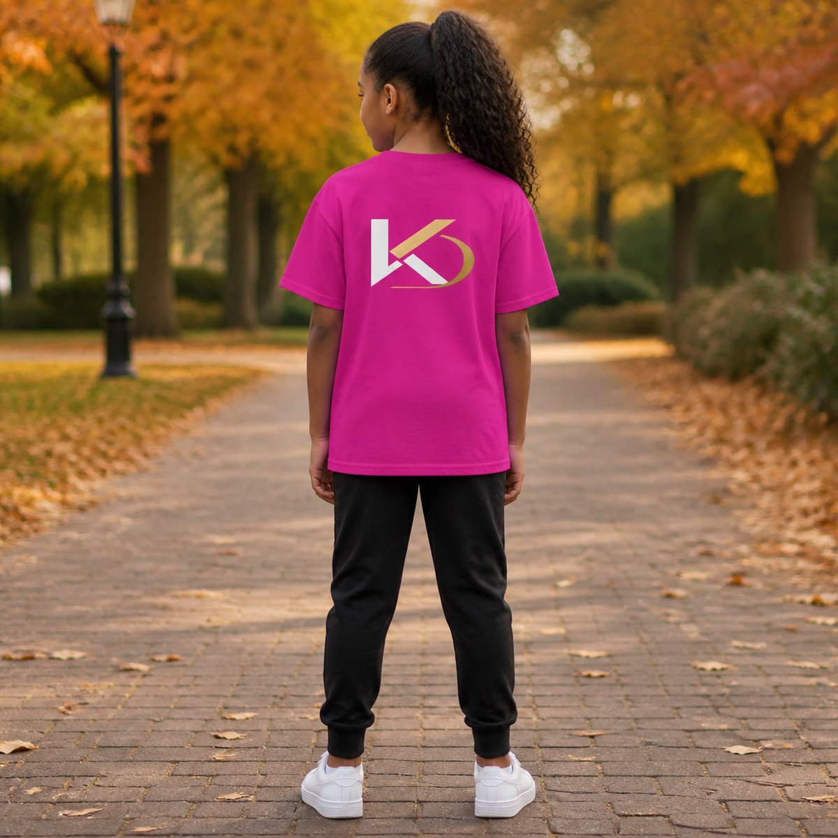 Cyber Pink KYNDEO Youth Pop Tee full back KD design on an Afro-Latina girl model in fall