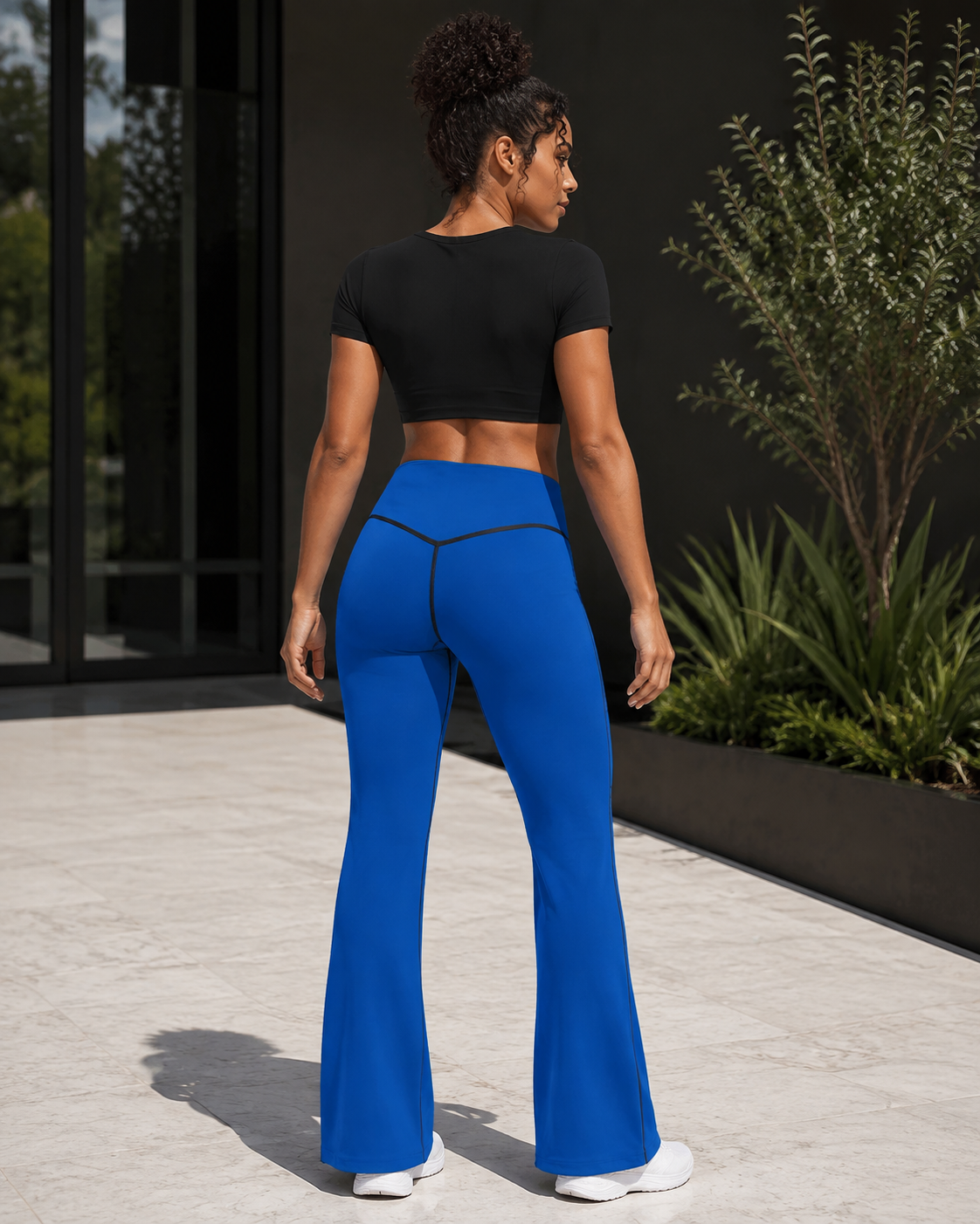 KYNDEO Contour Flare Pant — Royal Signature — rear three-quarter lifestyle view with black thread