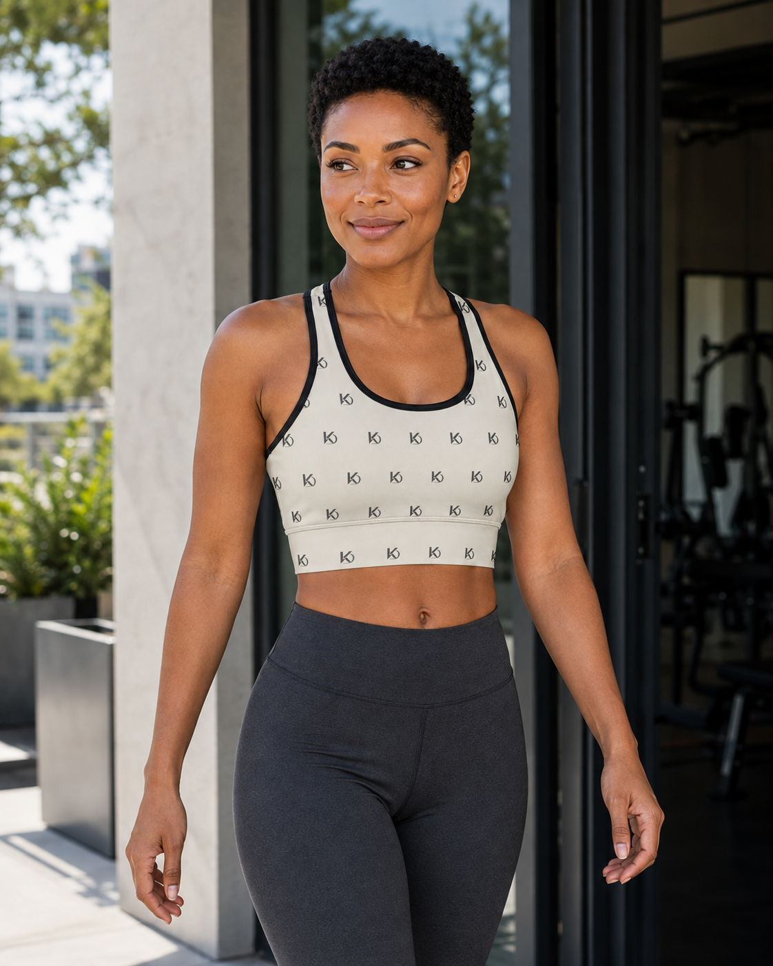 KYNDEO Form Crop Tank — Ivory Monogram, ivory with small charcoal KD monogram, front three-quarter lifestyle view